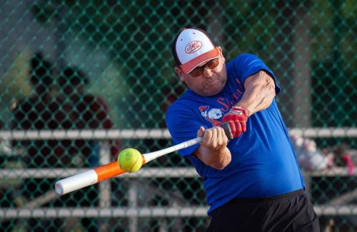 Male Softball player swinging a bat